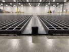 Two-part snap track bridging the butted edges of two matting rolls across a warehouse floor