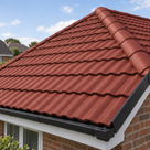Rustic brick red painted roof tiles, ridge run to the hip, neighbouring rooftops in the distance