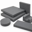 Grey foam pieces grouped on white: square pads, a disc, a bar and a curved saddle-shaped block