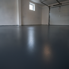 Dark grey satin alkyd floor paint freshly applied to a UK home garage concrete floor