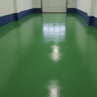 Mid green satin alkyd floor paint freshly applied to a UK home garage concrete floor