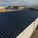 Black asbestos roof paint on a corrugated cement workshop roof in the UK