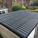 Charcoal asbestos roof paint on a corrugated cement garage roof in the UK