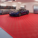 Red open-grid interlocking floor tiles in a home garage, purple-blue sports car and steel cabinets
