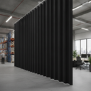 Black PVC strip curtain on a ceiling rail dividing warehouse racking from an open-plan office