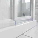 Clear bead-tipped seal along a white bifold door rail, meeting the edge of a white tray