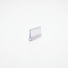 Clear seal offcut lying on white, flat rectangular body with a small round bead at one corner