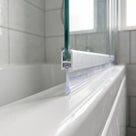 Clear bubble-bead bifold seal in a bath screen rail groove, blade and bulb sealing a 14-19mm gap to the bath