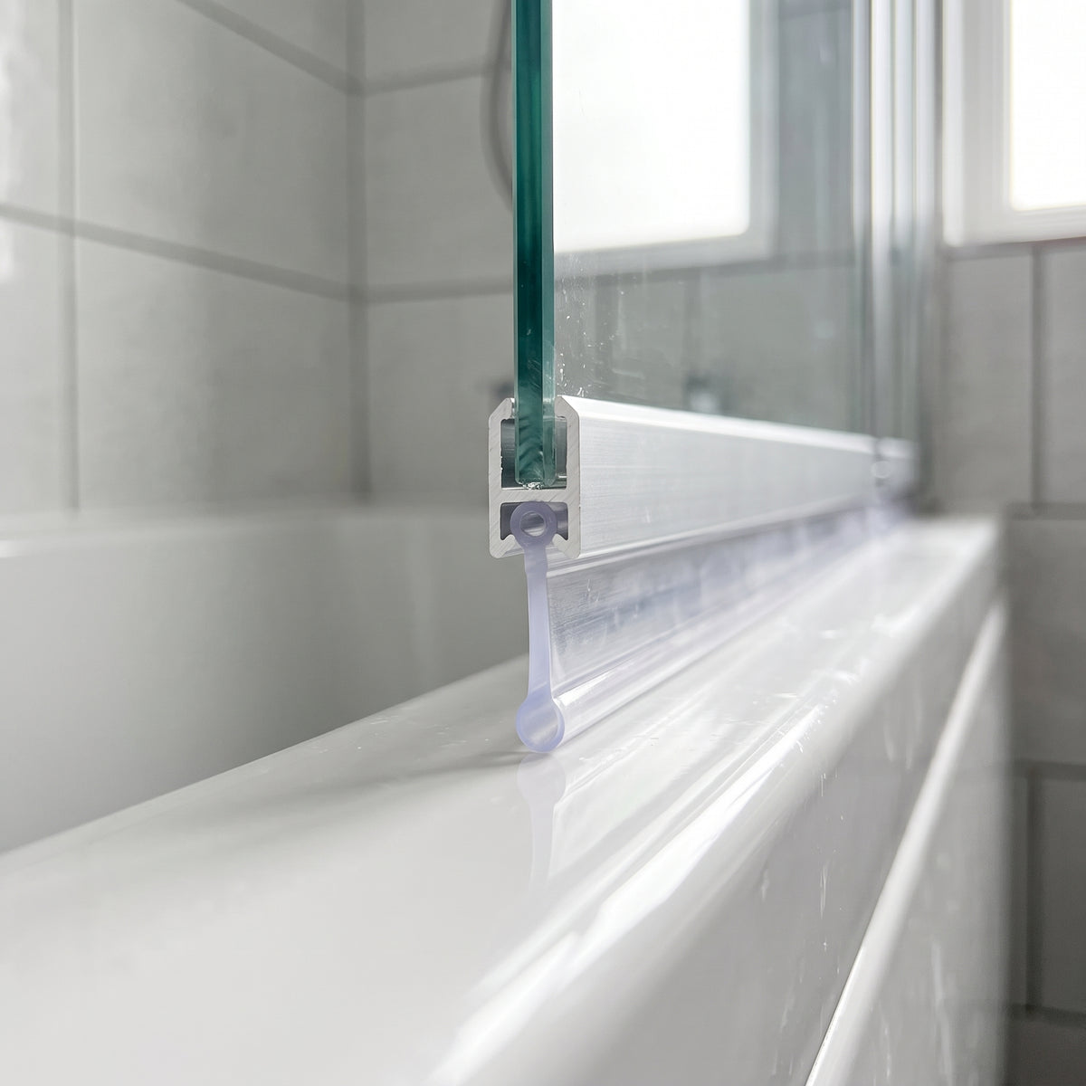 Clear bubble-bead bifold seal in a bath screen rail groove, blade and bulb sealing a 14-19mm gap to the bath
