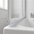 Clear seal with a short drop blade under a white bath screen rail, on a curved white bath