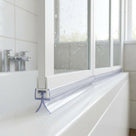 Clear seal with a half-round bulb and splayed feet under a white bath screen rail, on a white bath