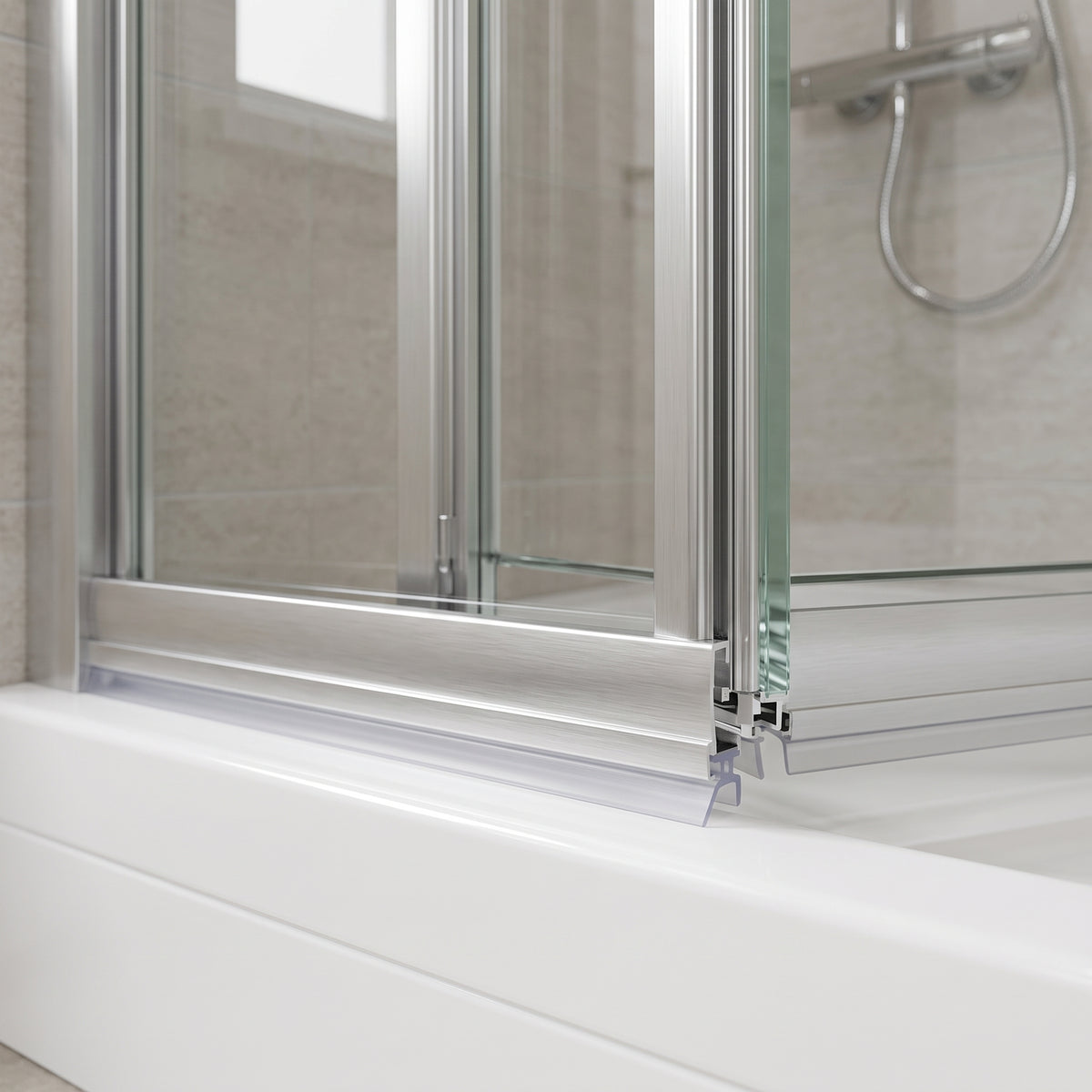 Clear seal beneath the brushed aluminium bottom rail of a folding shower door on a white tray