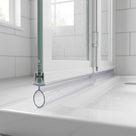 Clear seal with a large round bulb below a bifold screen bottom rail, sitting on a white shower tray