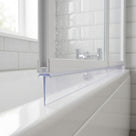 Long clear tapering seal under a white folding bath screen rail, resting on the white bath edge
