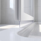 Tall clear blade seal dropping from a bifold door edge onto a sunlit white shower tray