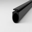 Black seal extrusion on white, T-rib along the top of a large hollow oval tube, cut end forward
