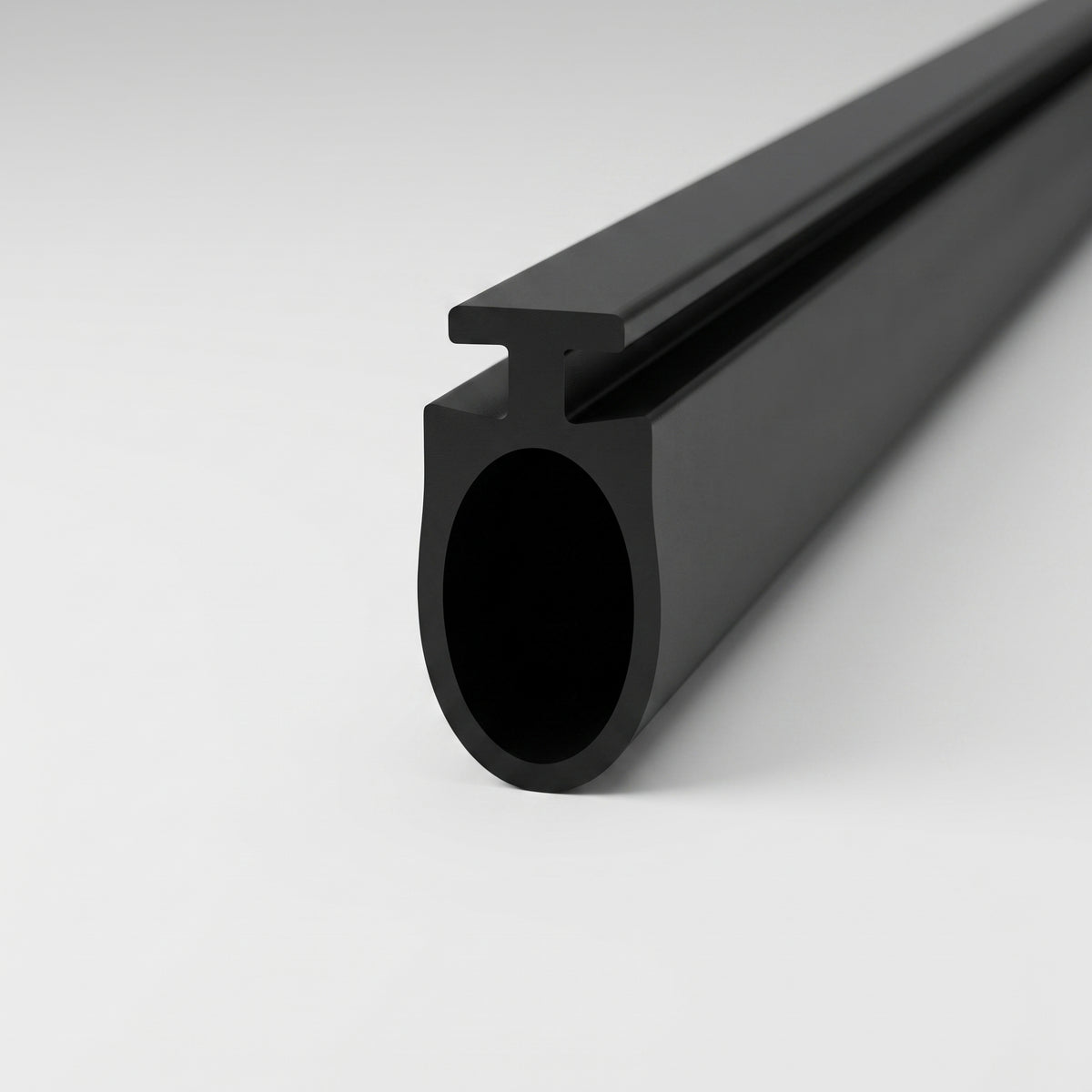 Black seal extrusion on white, T-rib along the top of a large hollow oval tube, cut end forward