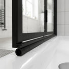 Black 6mm T-head seal fitted under the bottom rail of a black-framed bifold shower door