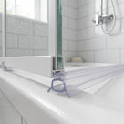 Clear seal with a hollow box and splayed legs under a white bath screen rail, on a white tray