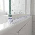 Clear seal with a fingered crown foot under a white bath screen rail, on a white bath
