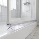 Clear angled-blade seal under a white bifold shower door on a tray, chrome shower valve behind