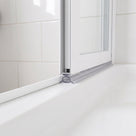 Clear oval-tube seal under a white bifold door rail, cushioning down onto a white bath top
