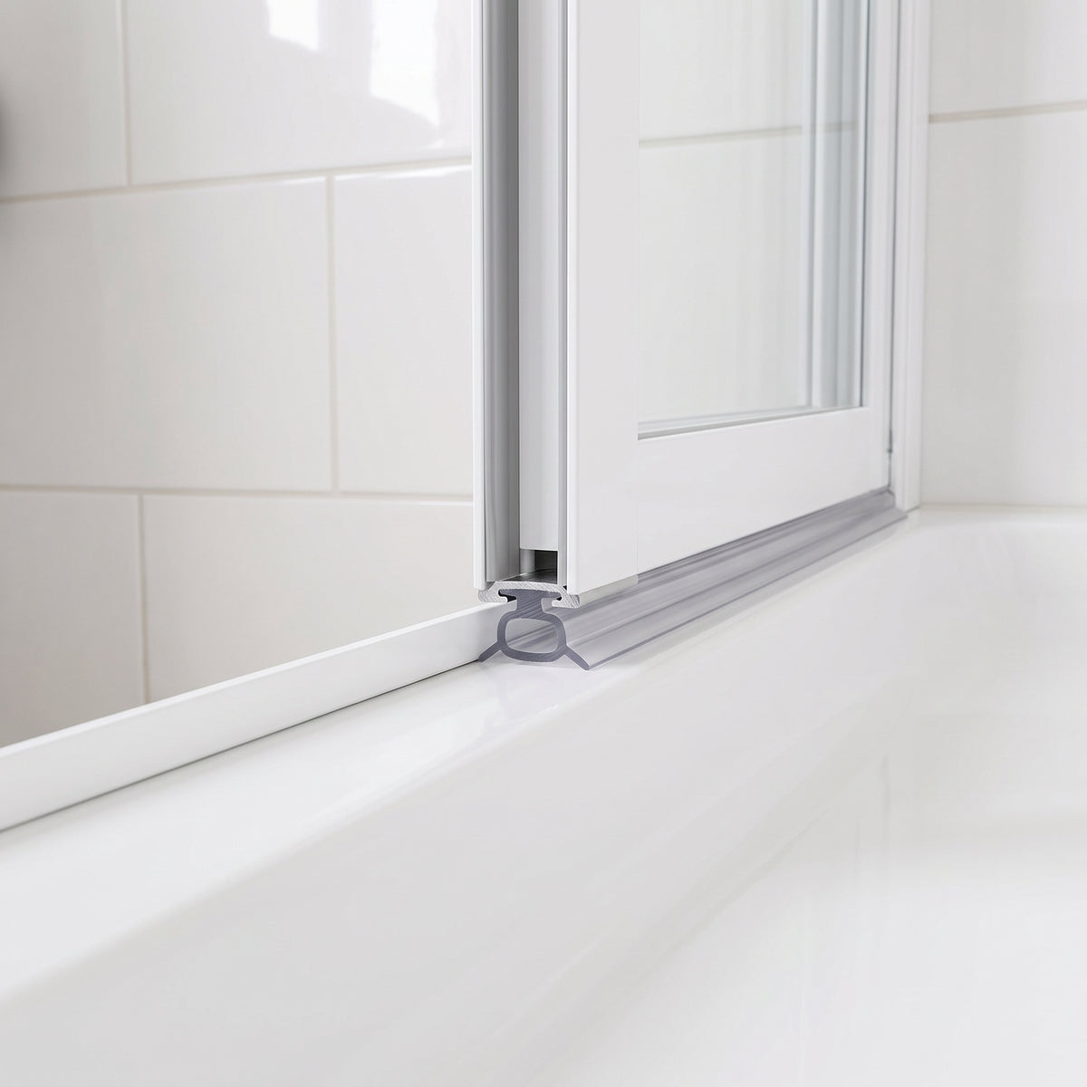 Clear oval-tube seal under a white bifold door rail, cushioning down onto a white bath top
