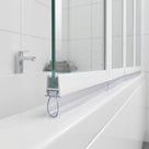 Clear channel seal fitted along the bottom of a 3-panel folding bath screen, sealing to the bath rim