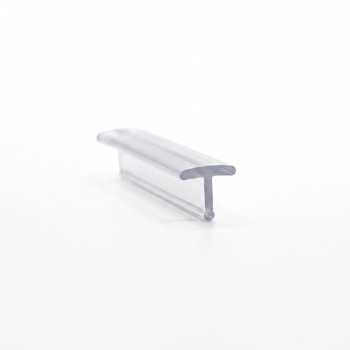 Short clear T-section seal on white, wide flat crown over a short stem, seen at a low angle