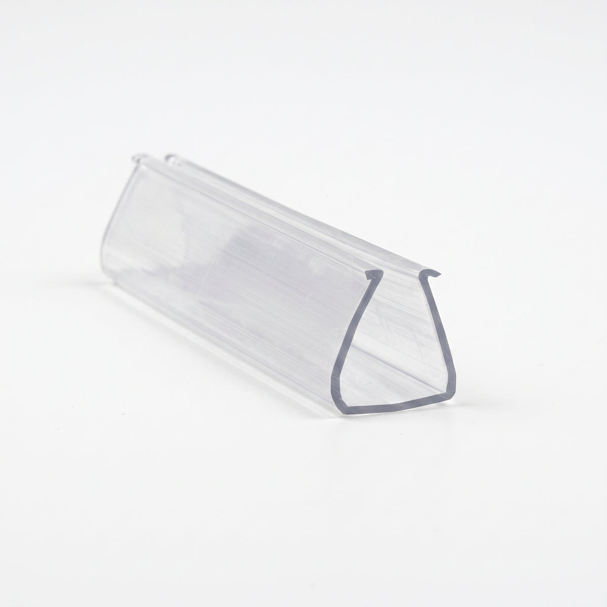 Clear PVC frame seal offcut on white, end-on view showing a deep U-channel with a lipped slot