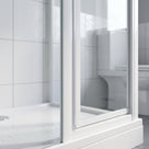 Clear seal in the upright of a white framed shower enclosure, white tiles and wet tray behind