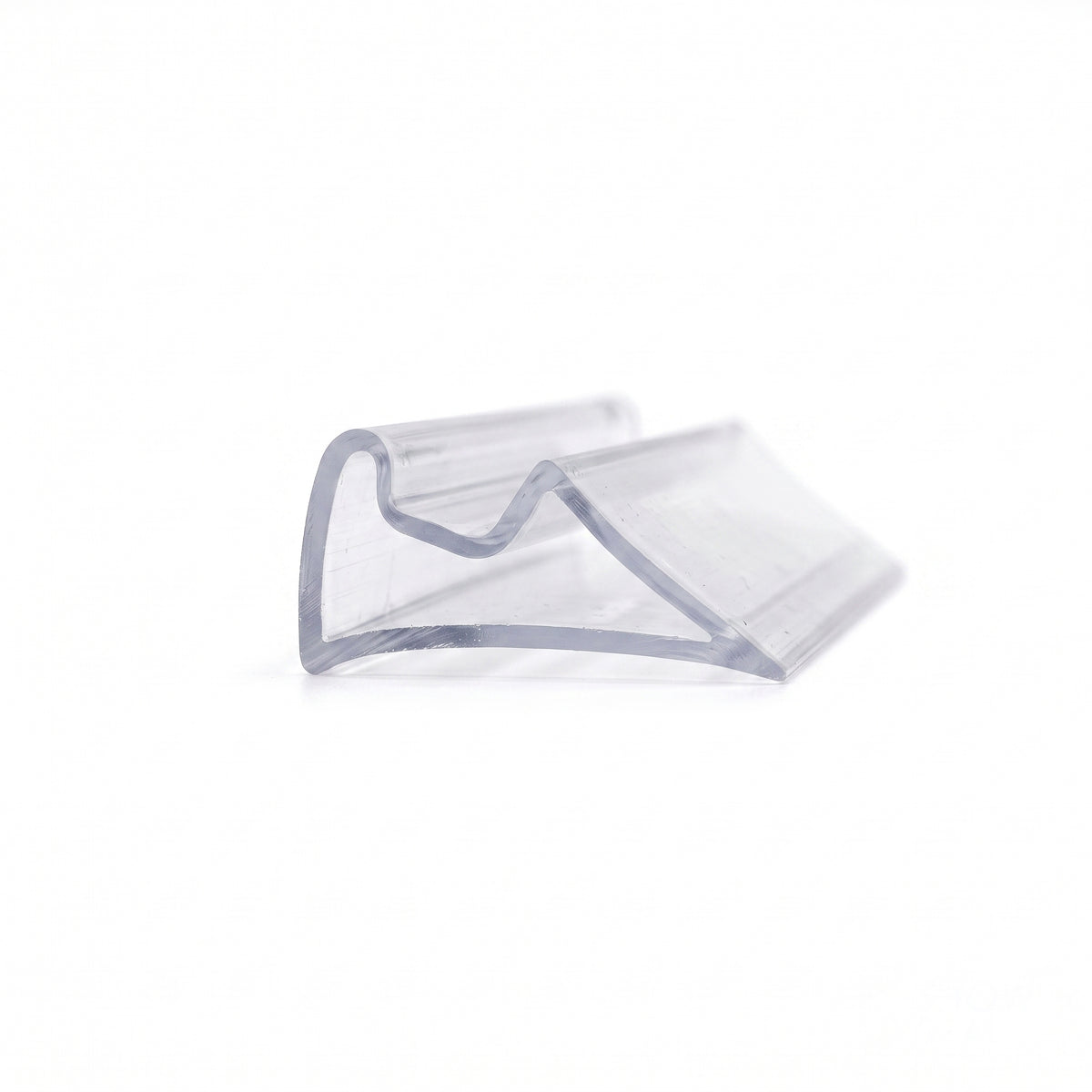 Clear PVC cushion seal offcut on white, folded wedge shape with a rounded hump and angled peak