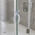 Clear bulb seal clipped over the vertical edge of a glass shower door, wet screen behind