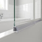 Clear seal slotted into the gap between glass pane and frame on a bifold bath screen bottom rail