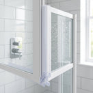 Clear seal down the vertical edge of a white-framed folding screen panel, white metro tiles behind