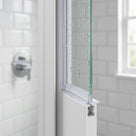 Slim clear seal down the vertical glass edge of a white-framed shower screen, white metro tiles behind