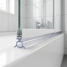 Clear seal with a hollow oval tube and splayed feet under a white bath screen rail, on a white bath