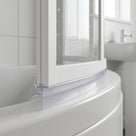 Clear seal following the curved bottom edge of a white bath screen on a rounded white bath