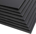 Fanned stack of black fluted corrugated plastic sheets on white, open flutes showing along the edges