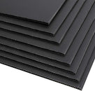 Fanned stack of black fluted corrugated plastic sheets on white, open flutes showing along the edges