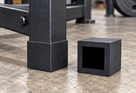 Illustrative black heavy-duty square rubber foot fitted to a straight square box-section frame
