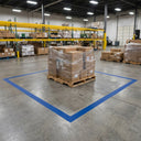Blue floor marking tape outlining a staging bay with a shrink-wrapped pallet standing inside it