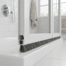 Brush seal with 5mm T backing and deep 12mm bristles bridging a large gap under a bifold shower door