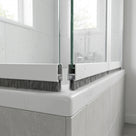 Brush seal with 5mm T backing and 8mm bristles fitted in the bottom channel of a bifold bath screen