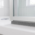 5mm x 12mm brush seal under a bifold shower door frame - grey bristles closing the gap to the tray