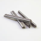 Several cut pieces of brush seal crossed on white, striped woven backing with long grey bristles