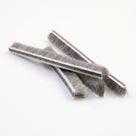 Three cut pieces of brush seal fanned across white, striped backing with deep grey bristles