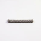 Cut length of brush seal on white, woven white backing above a soft grey bristle pile hanging down