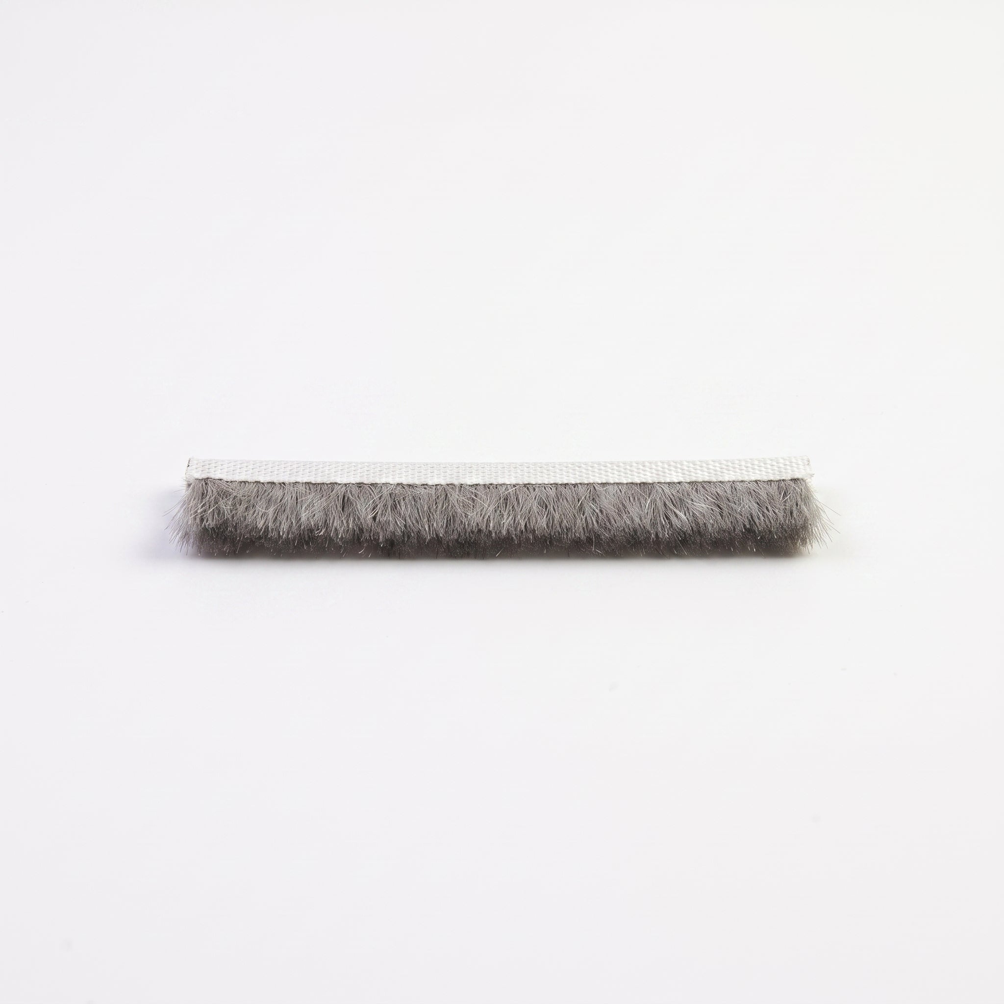 Cut length of BRUSH010 brush seal - white 7mm woven backing carrier with dense grey 8mm bristle pile