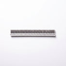 Long cut length of brush seal laid flat on white, woven backing with tall grey bristles standing up